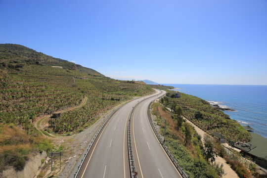 Empty asphalt highway curve running along the mediterranean sea coast