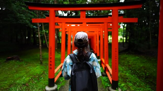 Woman Walking Through Torii Gates at Kashihara Jingu Shrine Japan