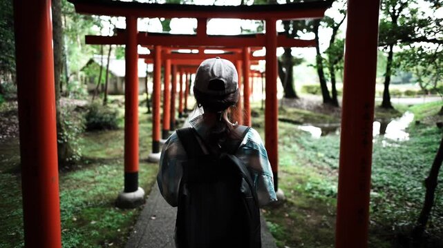 Woman Walking Through Torii Gates at Kashihara Jingu Shrine Japan