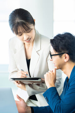 打ち合わせをする男女2人のビジネスマン