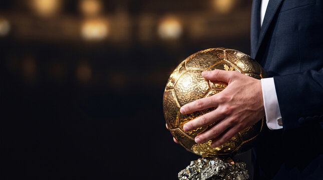 Homme en costume portant un troph&eacute;e de football dor&eacute;