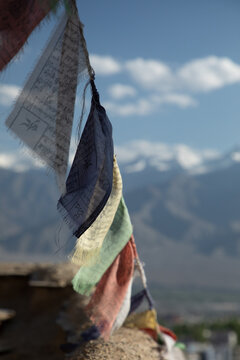 View of colorful prayer flags fluttering against the backdrop of the Himalayan mountains in Leh, Ladakh, India.
