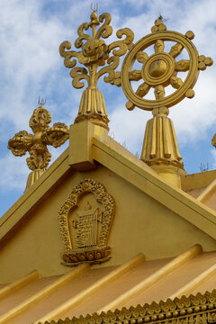 View of the golden roof of Namobuddha Monastery adorned with a dharma wheel and traditional Buddhist symbols under a blue sky in Simalchaur Syampati, Bagmati Province, Nepal.