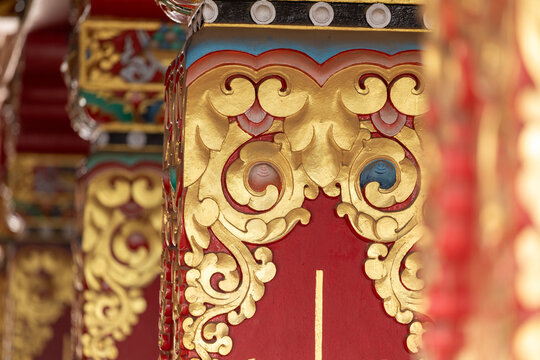 View of the ornate red and gold painted pillar with intricate traditional Buddhist carvings at Namobuddha Monastery in Simalchaur Syampati, Bagmati Province, Nepal.
