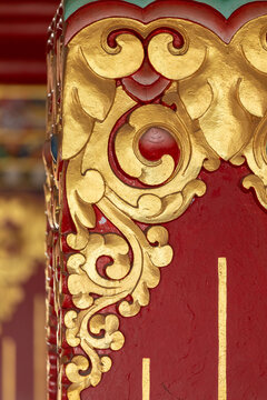 View of intricate gold-leaf carvings on a vibrant red pillar at Namobuddha Monastery in Simalchaur Syampati, Bagmati Province, Nepal.