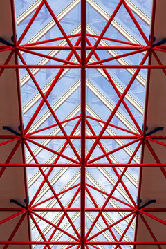 View of the red metal truss structure supporting the glass roof of Almere Centrum in Almere, Flevoland, Netherlands.