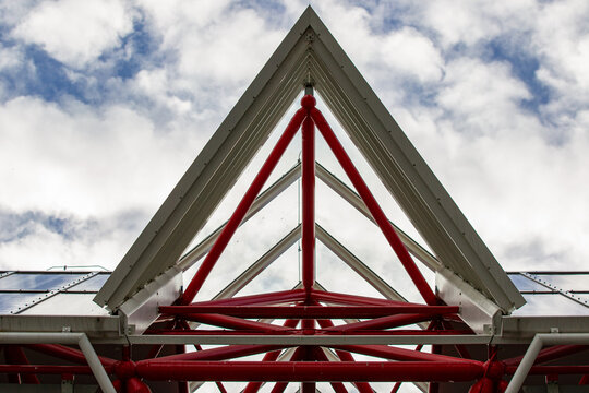 View of the modern red steel triangular roof structure of Almere Centrum against a cloudy sky in Almere, Flevoland, Netherlands.