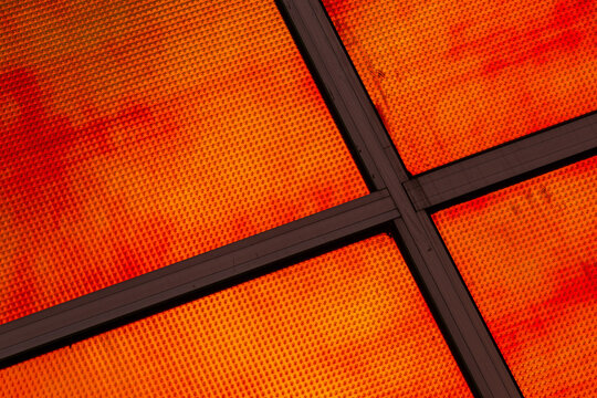 View of the vibrant orange textured facade of the La Defense building with dark structural framing in Almere, Flevoland, Nederland.