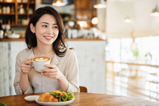 カフェでカフェラテを楽しむ女性