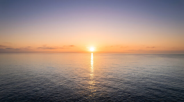 Serene Ocean Sunrise with Golden Sun Reflection on Calm Water and Soft Clouds