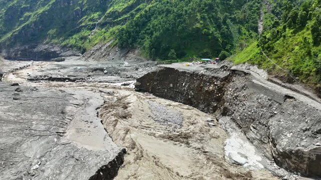 Kathmandu, Bagmati Province, Nepal - 31 August 2026: Aerial view of the Mailung Khola Jal Vidhyut Company Limited site showing extensive flood damage, mud-covered riverbanks, and debris in the valley.