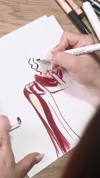 Vertical video. Designer workspace. Apparel sketch. Dressmaker creating modern female outfit with scarf. Woman hand drawing dress draft illustration.