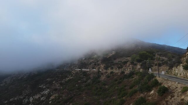 Fog rolling over a canyon road on a mountainside