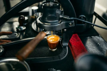 Barista brewing specialty coffee using a manual lever espresso machine at a slow bar. © artrachen