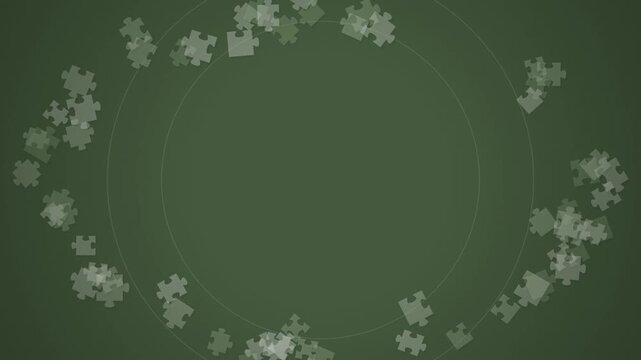 Puzzle pieces scattered across a green background forming a circular border with copy space.