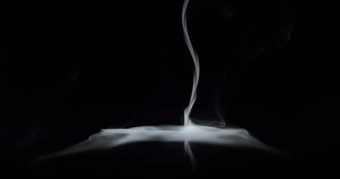Real swirling smoke spinning upwards and fading. Center vortex of wispy smoke spinning creating a mysterious ghostly aura of the paranormal or a spooky Halloween background visual effect overlay.