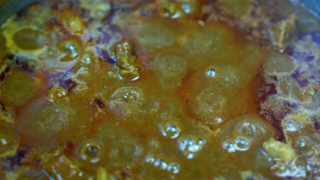 Close-up view of tender beef pieces coated in a rich, glossy brown curry sauce, showing a hearty and flavorful homemade mealabstract, texture, brown, earthy, organic, natural, wet, glossy, liquid