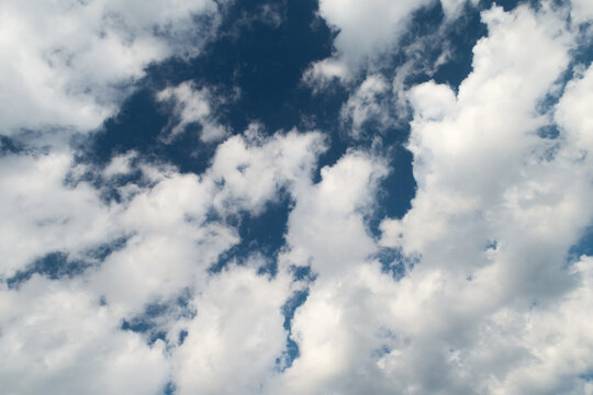 Cumulus fractus clouds against a deep blue sky background