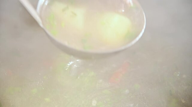 Hot broth cooking in a pot with vegetables and meat