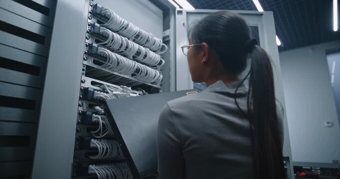 Female Technician Replaces Ethernet Switch in Server Rack Using Screwdriver. Concept of Professional Server Room Maintenance, Hardware Installation, Network Infrastructure Upgrade and Service.
