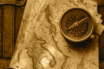 Old vintage maps and brass compass on top of a vintage leather luggage case. Vintage travel background backdrop concept. © Christian