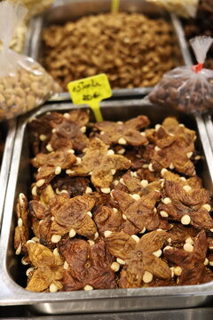 Star-shaped dried figs stuffed with almonds, a traditional Algarve sweet, in a metal tray at a market stall in Faro, Portugal