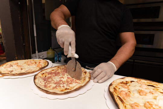 Preparing and slicing the tarte flamb&eacute;e on the bridge in "Little Venice" in Colamr, Alsace, France