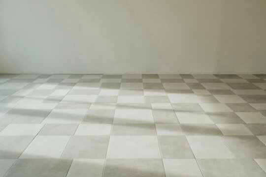 Pale square floor tiles in an empty sunlit room