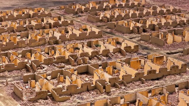 High angle view reveals ruined mud brick structures at the historical Lenghu Oil Base Site in Qinghai, China under daylight.