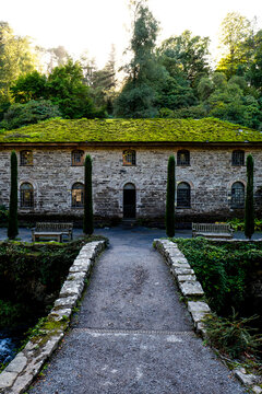 Old stone mill with a vibrant green moss covered roof