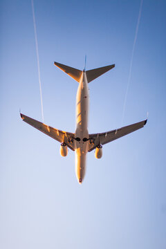 Low angle view of commercial airplane flying in clear blue sky