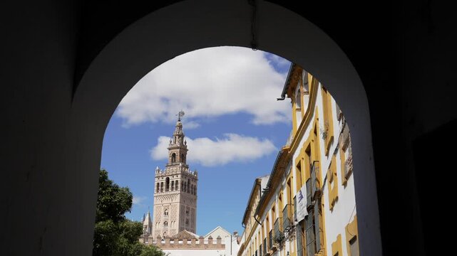 Cathedral de Seville framed through a historic architectural archway in Seville, Spain