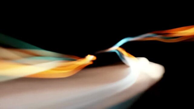 Vibrant light streaks moving across a dark space creating energy flow patterns with soft motion blur effects showcasing dynamic waves and glowing colorful ribbons of luminosity for creative