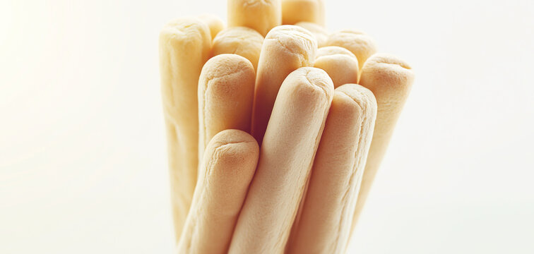 Italian breadsticks standing in a close bundle, emphasizing their pale golden crust, soft rounded ends, and crisp baked appeal
