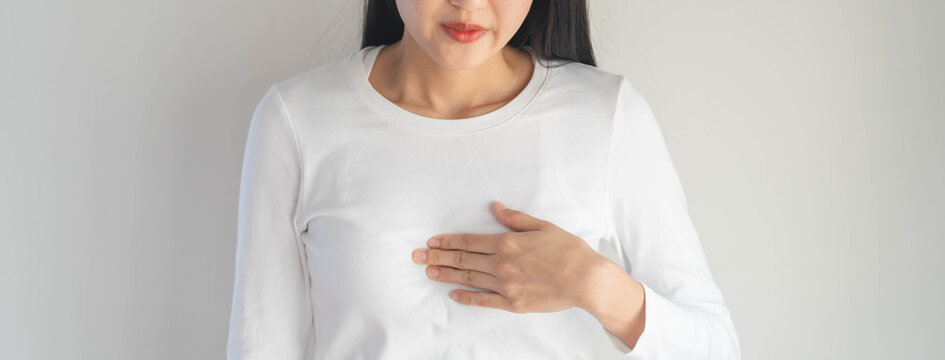Asian woman having reflux acids and pain in the chest.