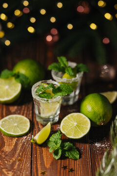 Tequila cocktail with lime and mint on a wooden table