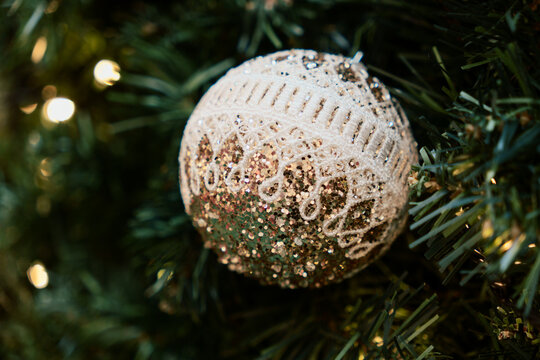 Glittering gold and white lace ornament on a Christmas tree