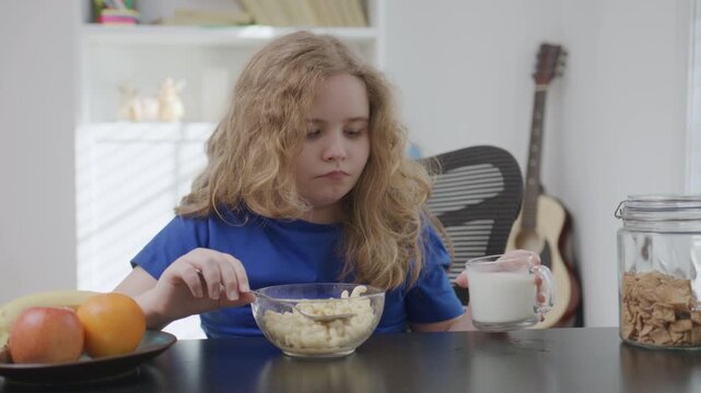 Child eating pasta at home. Child enjoying warm pasta meal. Child having healthy food indoors. Child sitting at table with pasta. Hungry kid eat paste for breakfast.