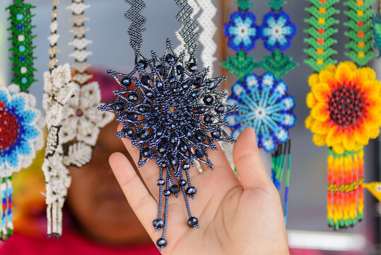 Female Hand Holding Black Bead Necklace at a Huichol Craft Market