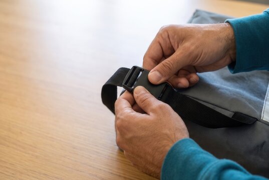 Hands fastening a reusable strap for secure transport