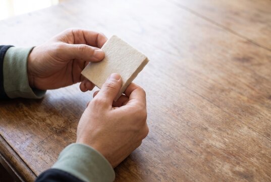 Hands checking the edge of a building insulation sample