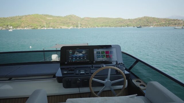 Luxury Yacht Flybridge Helm Station with Navigation Controls and Steering Wheel on a Sunny Summer Day