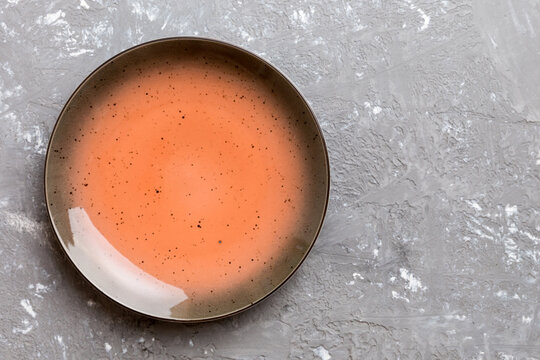 Top view of empty red plate on cement background. Empty space for your design