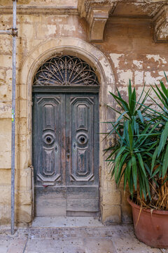 Weathered Vintage Wooden Arch Door with Circular Handles, Fanlike Iron Transom Grille