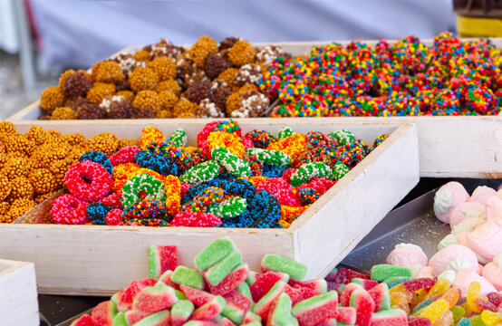 Colorful nonpareil covered gummy ring candies, pick and mix sprinkle sweets at candy shop display.