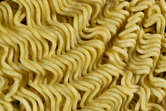 Macro pattern of dry yellow wavy instant noodles
