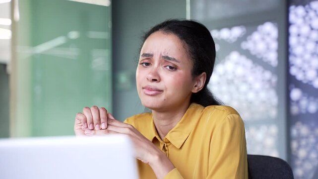 Close up of confused young businesswoman looking at laptop screen with doubt and frustration. Puzzled female professional having technical problem or difficult task at modern corporate workplace.