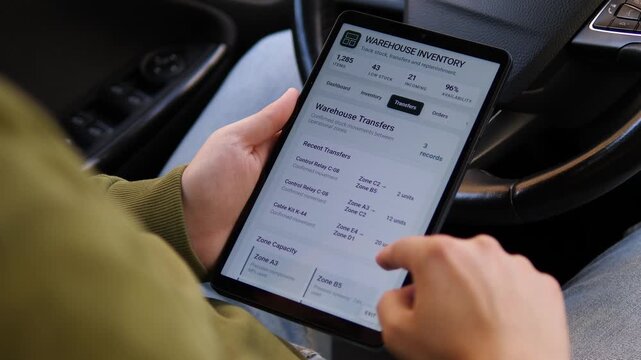 Worker reviews warehouse inventory and stock transfers on a tablet, highlighting digital logistics, real-time inventory control and modern supply chain management.