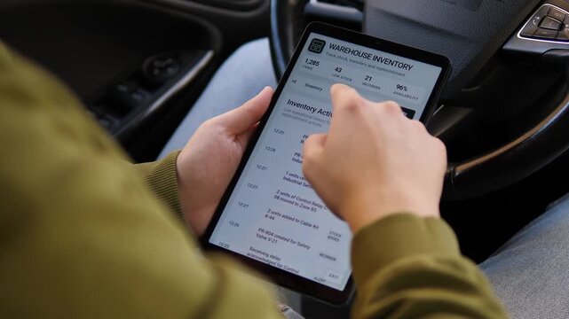 Worker reviews warehouse inventory activity and stock transfers on a tablet, highlighting digital logistics, real-time tracking and modern supply chain management.
