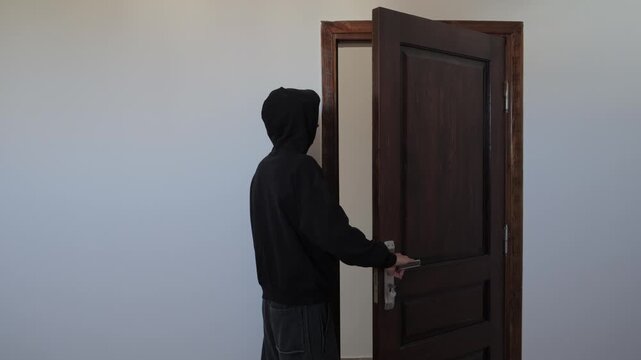 Man hesitating before leaving home, opening and closing the door while struggling with anxiety, avoidance and inner conflict, fear of going outside, isolation and emotional distress